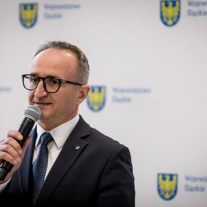 Grzegorz Boski, Wicemarszałek Województwa Śląskiego, przemawia na konferencji prasowej o programie wsparcia rodzinnych ogrodów działkowych. (wygenerowano przez AI)