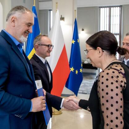 Grzegorz Boski, wicemarszałek Województwa Śląskiego, wręcza dokumenty działkom z rodzinnych ogrodów działkowych. (wygenerowano przez AI)