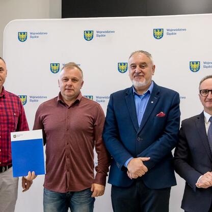 Grzegorz Boski, wicemarszałek Śląskiego, wręcza dokumenty odbiorcom wsparcia dla modernizacji rodzinnych ogrodów działkowych. (wygenerowano przez AI)