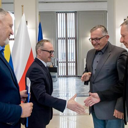 Wicemarszałek Grzegorz Boski i radny Marek Bieniek podczas ceremonii wręczenia dokumentów na modernizację rodzinnych ogrodów działkowych województwa śląskiego. (wygenerowano przez AI)