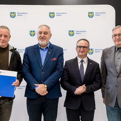 Wicemarszałek Grzegorz Boski i radny Marek Bieniek wręczają dokumenty dotyczące modernizacji ogrodów działkowych. (wygenerowano przez AI)