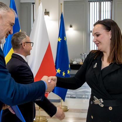 Formalne spotkanie w Sali Zgromadzeń Województwa Śląskiego, gdzie wicemarszałek Grzegorz Boski i radny Marek Bieniek wręczają finansowe wsparcie dla rodzinnych ogrodów działkowych. (wygenerowano przez AI)