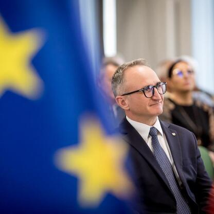 Grzegorz Boski, wicemarszałek Województwa Śląskiego, wręcza dokumenty finansowe działkom działkowcom podczas konferencji o wspieraniu rodzinnych ogrodów działkowych. (wygenerowano przez AI)