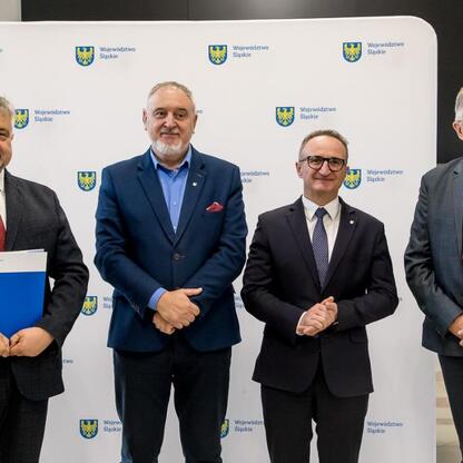 Wicemarszałek Grzegorz Boski i radny Marek Bieniek wręczają dokumenty finansowe dla modernizacji rodzinnych ogrodów działkowych województwa śląskiego. (wygenerowano przez AI)