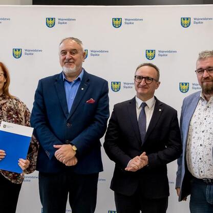 Wicemarszałek Grzegorz Boski wręcza dokumenty radnym Sejmiku Województwa Śląskiego, związanych z modernizacją rodzinnych ogrodów działkowych. (wygenerowano przez AI)