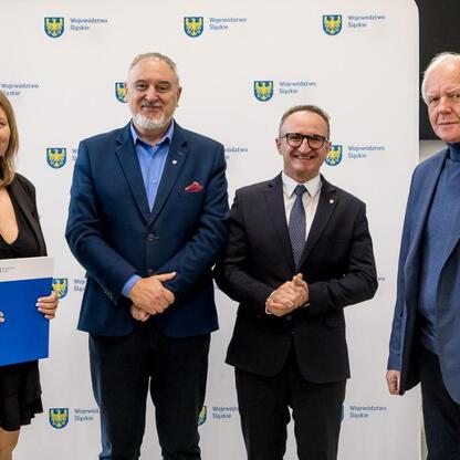 Wicemarszałek Województwa Śląskiego Grzegorz Boski i radny Marek Bieniek wręczają dokumenty działkom otrzymującym wsparcie finansowe dla modernizacji ogrodów. (wygenerowano przez AI)