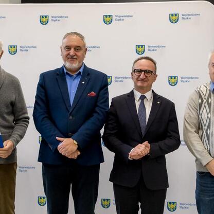 Grzegorz Boski, wicemarszałek Województwa Śląskiego, wręcza dokumenty z finansowym wsparciem dla rodzinnych ogrodów działkowych. (wygenerowano przez AI)