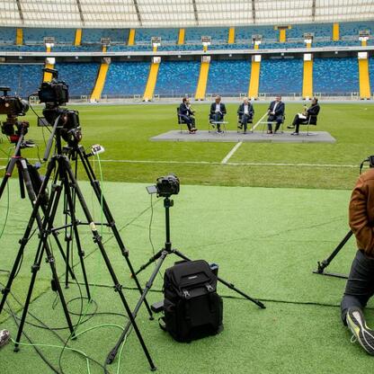 Panel dyskusyjny na Superauto.pl Stadion Śląskim, z czterema uczestnikami debaty o organizacji Mistrzostw Europy w Lekkoatletyce w 2028 roku. (wygenerowano przez AI)