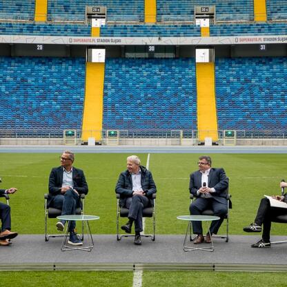 Panel dyskusyjny na Superauto.pl Stadion Śląskim, gdzie Wojciech Saługa i inni debatują o organizacji Mistrzostw Europy w Lekkoatletyce w 2028 roku. (wygenerowano przez AI)
