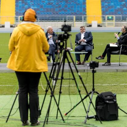 Panel dyskusyjny na Superauto.pl Stadion Śląskim, z udziałem Wojciecha Saługi i innych ekspertów. (wygenerowano przez AI)
