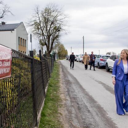 Dwie kobiety, Joanna Bojczuk i Sylwia Cieślar, spacerują wokół Pawła Stalmacha Primary School w Bażanowicach, omawiając plany budowy nowej sali gimnastycznej. (wygenerowano przez AI)