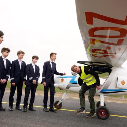 Grupa osób omawia samolot Pipistrel Velis Electro na lotnisku Katowice. (wygenerowano przez AI)