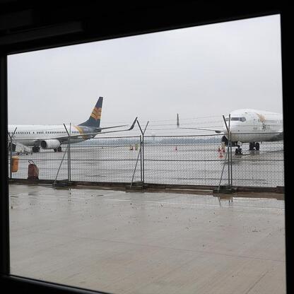 Widoczny jest widok z hangaru H4 Katowice Airport, gdzie dwie samoloty są przygotowane do obsługi technicznej. (wygenerowano przez AI)