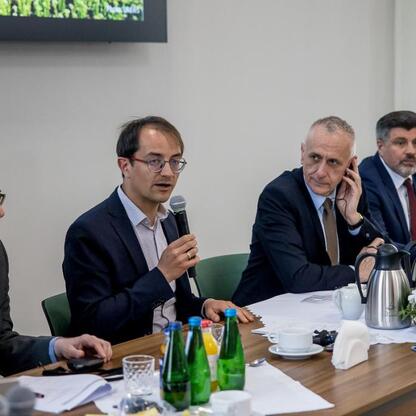 Wicemarszałek Leszek Pietraszek koordynuje spotkanie z niemiecką delegacją w Sali Konferencyjnej. (wygenerowano przez AI)