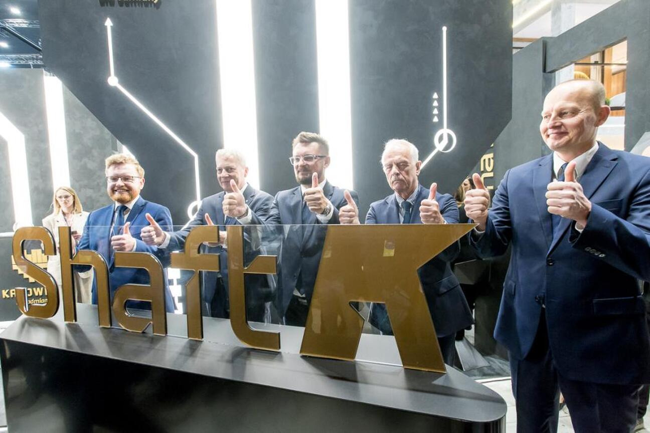 Grupa men w garniturach i krawatach omawia projekt "SHAFT K" w Katowicach. (wygenerowano przez AI)