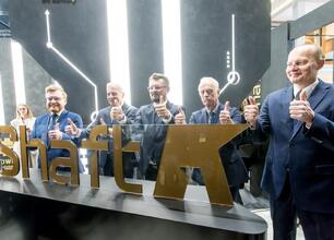 Grupa men w garniturach i krawatach omawia projekt "SHAFT K" w Katowicach. (wygenerowano przez AI)
