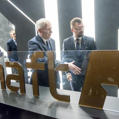 Grupa men w garniturach i krawatach omawia projekt 