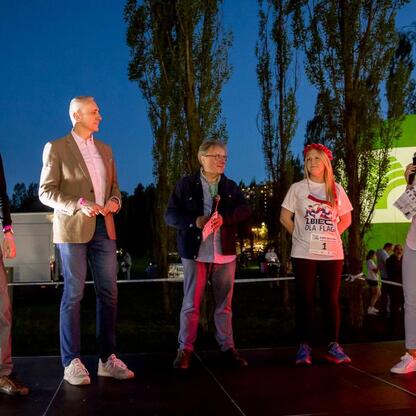 Grupa osób na scenie podczas Biegu dla Flagi w Tauron Parku Śląskim. (wygenerowano przez AI)