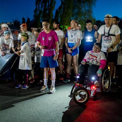 Zapoczątkowany bieg dla Flagi w Tauron Parku Śląskim, gdzie uczestnicy, w tym Leszek Pietraszek i Joanna Bojczuk, zebrańi pod nocy światłem, uczcili Dzień Flagi RP. (wygenerowano przez AI)