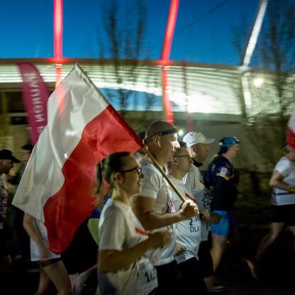 Zapoczątkowany bieg dla Flagi w Tauron Parku Śląskim, uczestnicy w biało-czerwonych koszulkach. (wygenerowano przez AI)