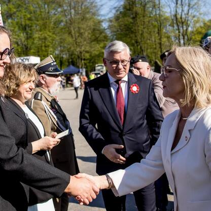 Grupa osób uczestniczących w Śląskim Capstrzyku w Tauron Parku Śląskim, oddając hołd 105. rocznicy III Powstania Śląskiego i Dniu Flagi RP. (wygenerowano przez AI)