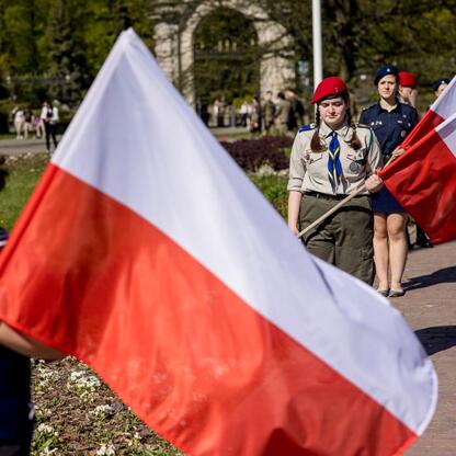 Zwycięski marsz harcerzy z flagami na Śląskim Capstrzyku w Tauron Parku Śląskim. (wygenerowano przez AI)