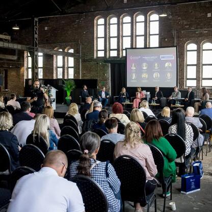 Konferencja w Muzeum Hutnictwa Cynku Walcownia w Katowicach, skupiająca się na rewitalizacji przemysłowych terenów dla turystyki i biznesu. (wygenerowano przez AI)