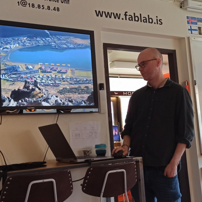 Zdjęcie przedstawia osobę prowadzącą warsztat edukacyjny w FAB-LAB-ie , która stoi przy tablicy.