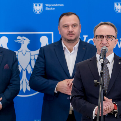 Trzech mężczyzn podczas uroczystego wręczenia umów dla LGD w ramach rozwoju obszarów wiejskich województwa śląskiego. (wygenerowano przez AI)