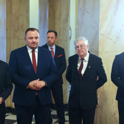 Grupa mężczyzn w strojach formalnych na uroczystości podpisania Memorandum o współpracy Śląskiego Voivodztwa i Rządu Walii. (wygenerowano przez AI)