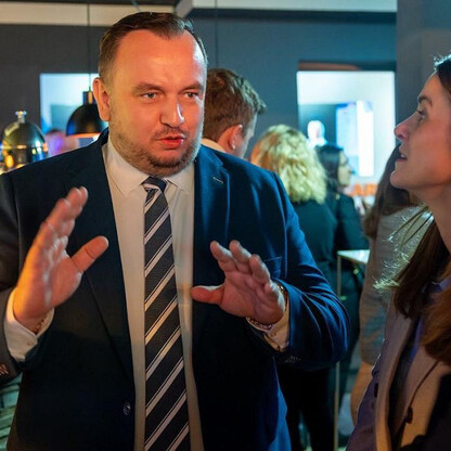 Mężczyzna w garniturze prowadzi rozmowę z kobietą na forum ekonomicznym w Davos. (wygenerowano przez AI)