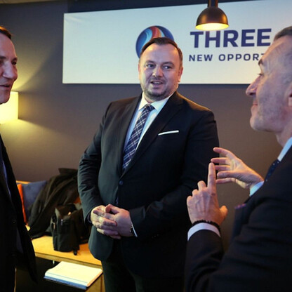 Trzech mężczyzn w strojach formalnych rozmawiających w profesjonalnym środowisku, podczas spotkania na Światowym Forum Ekonomicznym w Davos. (wygenerowano przez AI)