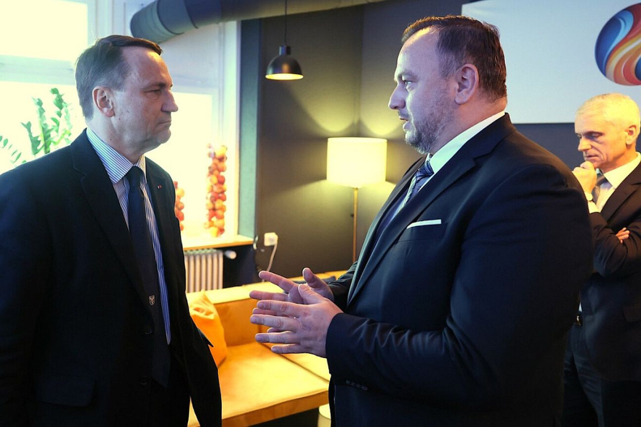 Dwa mężczyźni w strojach formalnych omawiają tematykę współpracy transgranicznej podczas Światowego Forum Ekonomicznego w Davos. (wygenerowano przez AI)