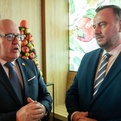 Dwa mężczyźni w strojach formalnych omawiają tematykę współpracy transgranicznej podczas Światowego Forum Ekonomicznego w Davos. (wygenerowano przez AI)