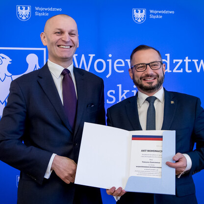 Dwóch mężczyzn w strojach formalnych otrzymuje powołania do Wojewódzkiego Zespołu Koordynacji województwa śląskiego. (wygenerowano przez AI)