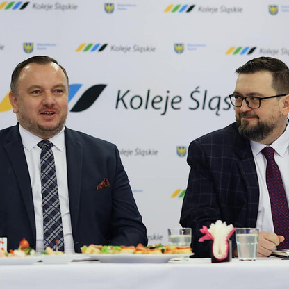 Dwa mężczyźni omawiają sukcesy Kolei Śląskich w 2023 roku. (wygenerowano przez AI)