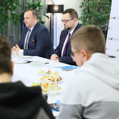 Formalne spotkanie w konferencyjnym pomieszczeniu Kolei Śląskich, gdzie dyskutują o sukcesie spółki. (wygenerowano przez AI)