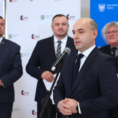 Podczas konferencji prasowej o budowie mostu na Odrze, marszałek województwa Jakub Chełstowski przemawia do mediów, podkreślając znaczenie inwestycji dla gospodarki regionu. (wygenerowano przez AI)