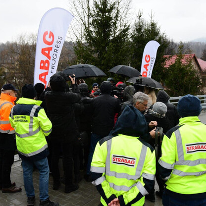 Grupa pracowników w niebieskich kamizelkach z logo 