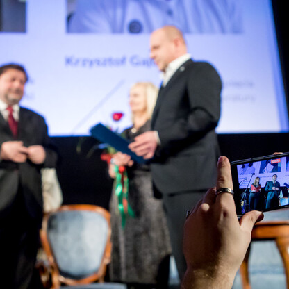 Zdjęcie przedstawia uroczystość wręczenia nagród Marszałka Województwa Śląskiego Culture Awards, która odbyła się w katowickim kinoteatrze Rialto. Uczestnicy, w tym darczyńcy i laureaci, stoją na scen (wygenerowano przez AI)