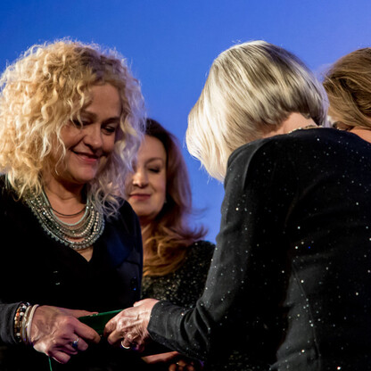 Podczas uroczystości wręczenia nagród Marszałka Województwa Śląskiego Culture Awards, trzy kobiety omawiają nagrodę, którą otrzymały. (wygenerowano przez AI)