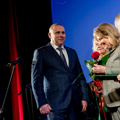 Na zdjęciu: Uroczystość wręczenia nagród Marszałka Województwa Śląskiego w kinoteatrze Rialto. Uczestnicy otrzymują kwiaty, podczas gdy dwie damy w strojach formalnych prezentują nagrody. Atmosfera fo (wygenerowano przez AI)