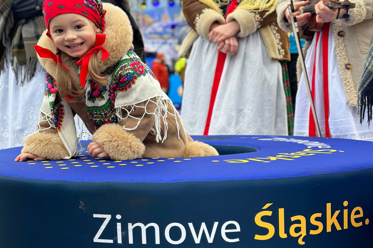 Młoda dziewczyna w tradycyjnym stroju zimowym uczestniczy w festiwalu "Projekt Zima" na Szczyrku, gdzie tworzy mydło z aktywnym węglem. (wygenerowano przez AI)