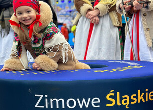Młoda dziewczyna w tradycyjnym stroju zimowym uczestniczy w festiwalu "Projekt Zima" na Szczyrku, gdzie tworzy mydło z aktywnym węglem. (wygenerowano przez AI)