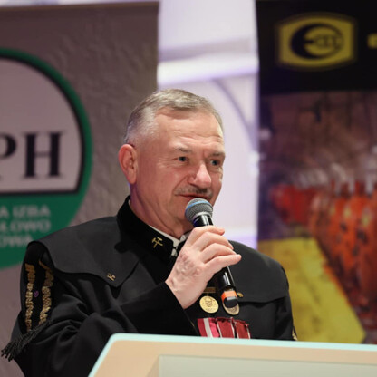 Mężczyzna w mundurze wojskowym przemawia do mikrofonu podczas uroczystości w GIPH, Katowice. (wygenerowano przez AI)