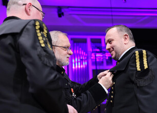 Formalny koncert noworoczny w Filharmonii Śląskiej, gdzie dyrygent prowadzi orkiestrę, a publiczność śledzi muzykę. (wygenerowano przez AI)