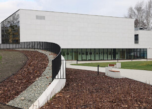Pszczyńskie Centrum Kultury, nowoczesny budynek z dużymi oknami i zieleńią. (wygenerowano przez AI)