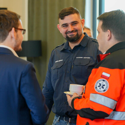 Ratownicy medyczni i pracownicy Kolei Śląskich omawiają współpracę w Katowicach. (wygenerowano przez AI)