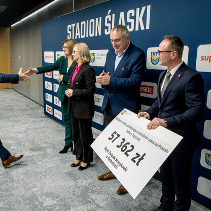 Grzegorz Boski, wiceprzewodnicząca Urszula Koszutska i radni wręczają symboliczne czeki na Stadionie Śląskim. (wygenerowano przez AI)