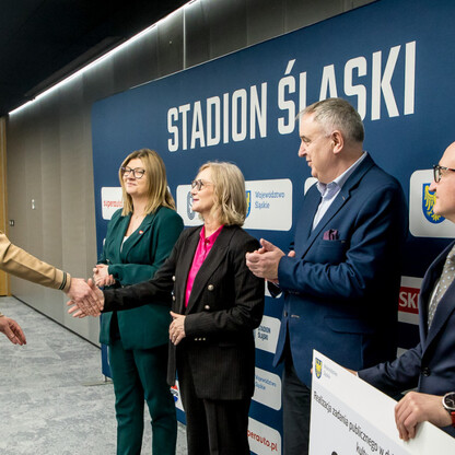 Grzegorz Boski, wicemarszałek województwa, prezentuje symboliczne czeki na Stadionie Śląskim. (wygenerowano przez AI)